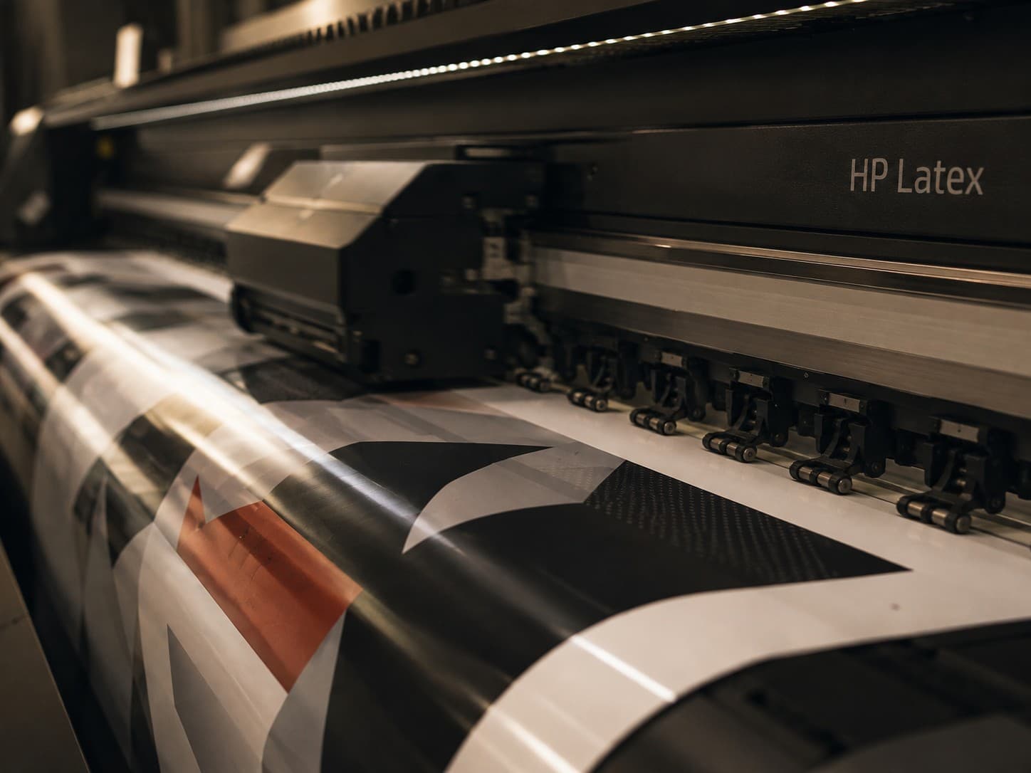 A large-format printer producing a custom vehicle graphic in-house